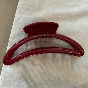 Grande molletta per capelli bordeaux con scritte dorate su sfondo di juta beige