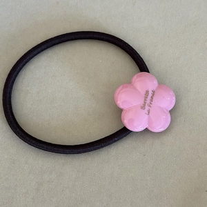 Detail of flower hair tie with Barrette La France text and pink decorative floral charm