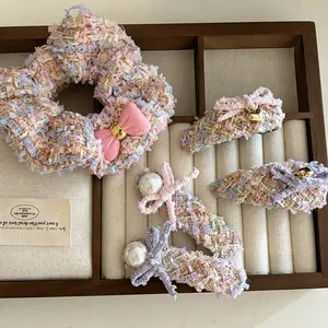 Detail of pink tweed hair accessories set with bows, pearls, and golden heart charms