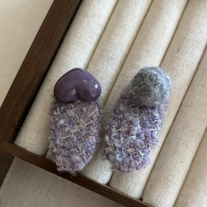 Détails rapprochés de barrettes tricotées avec décor de cœur et pompons doux