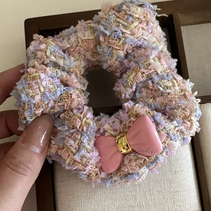 Detail of pink tweed scrunchie featuring a lovely bow and elegant woven texture
