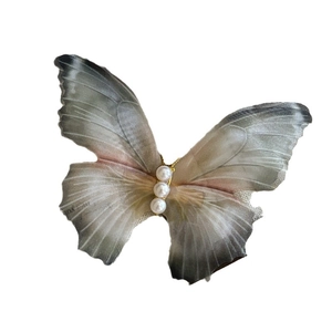 Barrette papillon élégante en tulle avec trois perles et ailes dégradées sur fond blanc