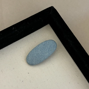 Classic dark blue denim fabric oval hair clip displayed on a minimalist cream canvas tray
