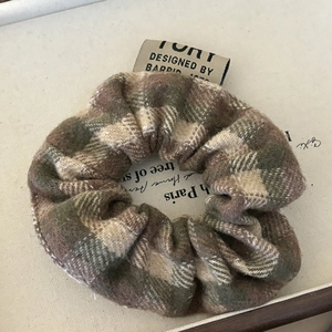 Vintage green plaid oversized scrunchie with designer label on a retro background
