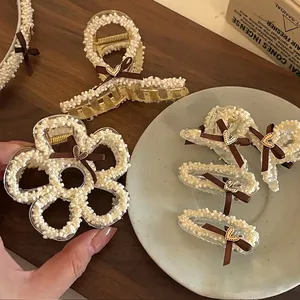 Set de pinces à cheveux avec nœud marron, perles et détails de cœur dorés