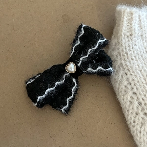 Elegant black sequin bow hair clip with white plush trim and heart pearl center