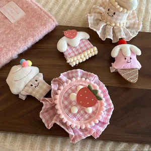 Détail macro de pinces à cheveux en peluche fraise et cupcake sur plateau bois
