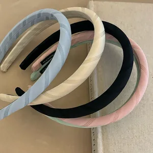 Detail of handmade padded satin headbands with twill texture and logo label