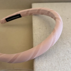 Detail view of pink striped fabric headband with handmade sewing label inside