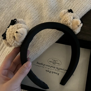 Détail du serre-tête en satin noir avec deux oursons en peluche beige et nœuds
