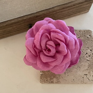 Detailed close-up of handmade 3D fabric rose hair claw clip with linen texture petals