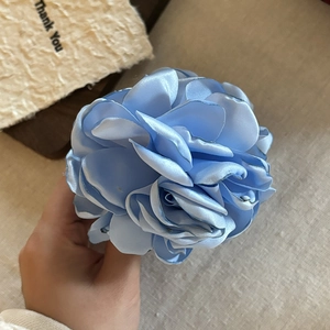 Handheld light blue satin rose hair claw clip with a 3D layered fabric flower design