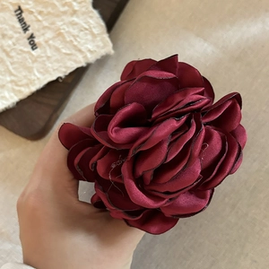Close-up of a burgundy satin 3D rose hair claw clip with black edge detailing