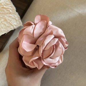 Detailed close-up showing the soft pink satin rose fabric and smooth layered petals