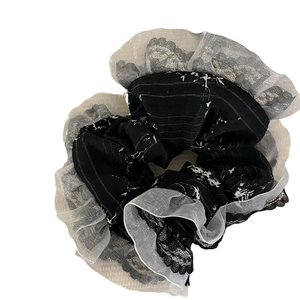 Elegant black scrunchie with white lace edges and floral pattern for hair styling