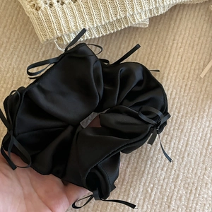 Détail d'un chouchou en satin noir avec de petits nœuds en ruban de style ballerine