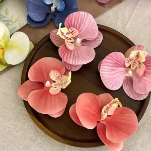 Lifelike Phalaenopsis orchid hair clips in various colors displayed on a wooden tray