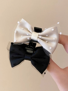 Detail of small bow hair clips with black lace mesh trim and satin polka dot fabric