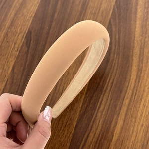 Macro detail of nude beige padded sponge headband featuring soft matte fabric texture