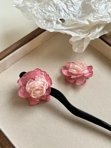 Detail view of pink gradient fabric flower hair stick set in a beige display box