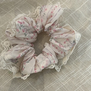 Chouchou en dentelle florale en mousseline avec motif de fleurs mauves sur fond de lin