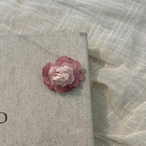 Detail of pink silk flower hair clip showing delicate fabric layers and soft gradient