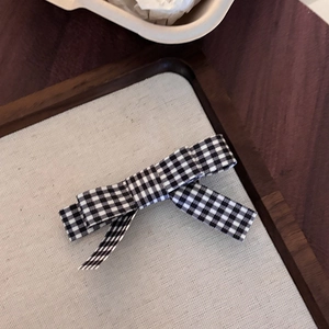 Detailed macro view of black and white gingham checkered fabric bow hair clips