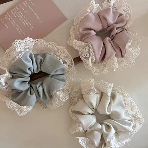 Lot de trois chouchous en dentelle rose poudré, vert sauge et blanc crème