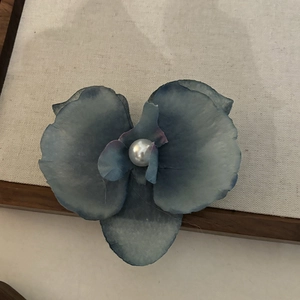 Détail de la pince à cheveux orchidée en tissu dégradé bleu avec perle blanche centrale
