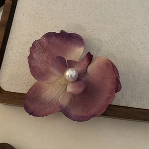 Détail macro d'une pince à cheveux orchidée avec pétales violets et perle centrale