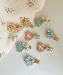 Detail of Korean style floral and pearl hair clips set in pink and mint macaron tones