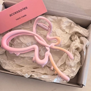 Pince à cheveux papillon rose mat présentée dans une boîte cadeau avec papier soie