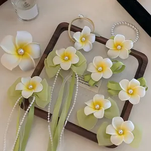 Detailed set of Frangipani hair clips with pearls, green ribbons, and silk flowers