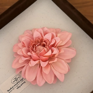 Dettaglio della clip per capelli dahlia rosa con petali in tessuto ed etichetta vintage