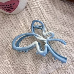 Pince à cheveux papillon dégradé bleu avec texture mate sur fond en tissu tissé