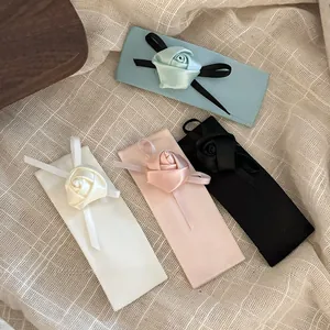 Vue détaillée du lot de quatre barrettes à fleurs en ruban bleu, rose, blanc et noir