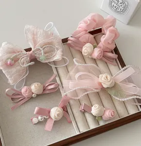 Détail d'accessoires de cheveux fleurs rose clair avec nœuds dentelle et perles