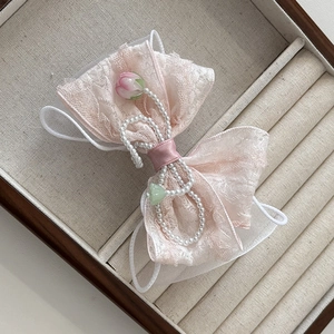Nœud à cheveux en dentelle rose avec perles et tulipes dans un écrin vintage
