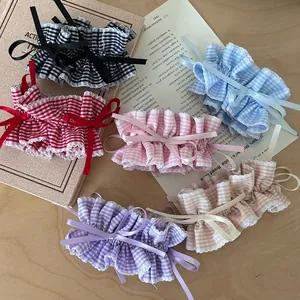 Detail of five plaid scrunchies with delicate ribbon bows in sweet academy style