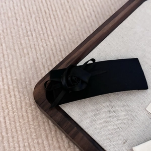Gros plan sur pince à cheveux fleur en soie noire avec nœud vintage sur tissu