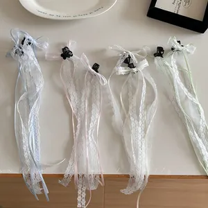 Detailed view of lace bow hair clips in light blue, pink, cream, and green colors