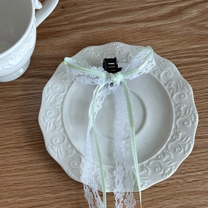 Sweet white lace bow hair claw clip with light green ribbons on vintage porcelain plate