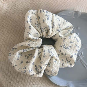 Chouchou élégant à fleurs bleues sur un plateau décoratif en céramique bleue