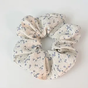 Chouchou à imprimé floral avec motifs de fleurs bleues sur tissu blanc doux