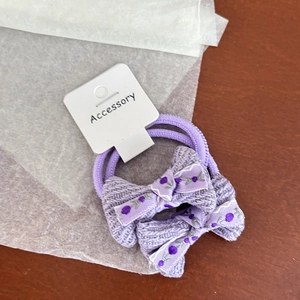 Gros plan de pinces à cheveux nśuds violet taro sur carte d'accessoires blanche