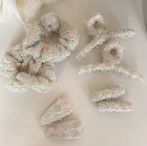 Dettaglio del set di accessori per capelli in chiffon floreale con mollette e elastici