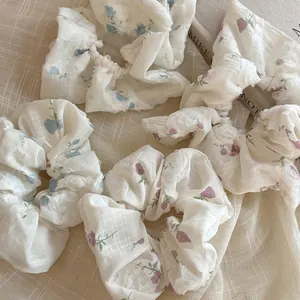 Floral print scrunchie set with blue and purple patterns on textured fabric surface