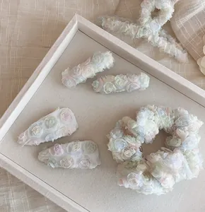 Vista macro del set di fermagli per capelli e elastici con fiori fatti a mano