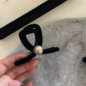 Elegant black flocked hair claw clip with a large pearl accent for women's hair styling