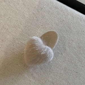 Dettaglio del fermaglio per capelli a cuore in velluto rosa con morbida texture floccata
